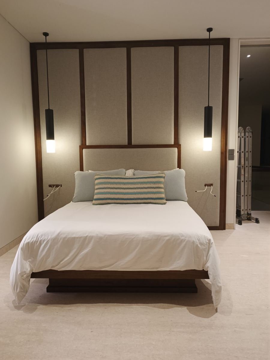Bed with an upholstered panel headboard and pendant lights