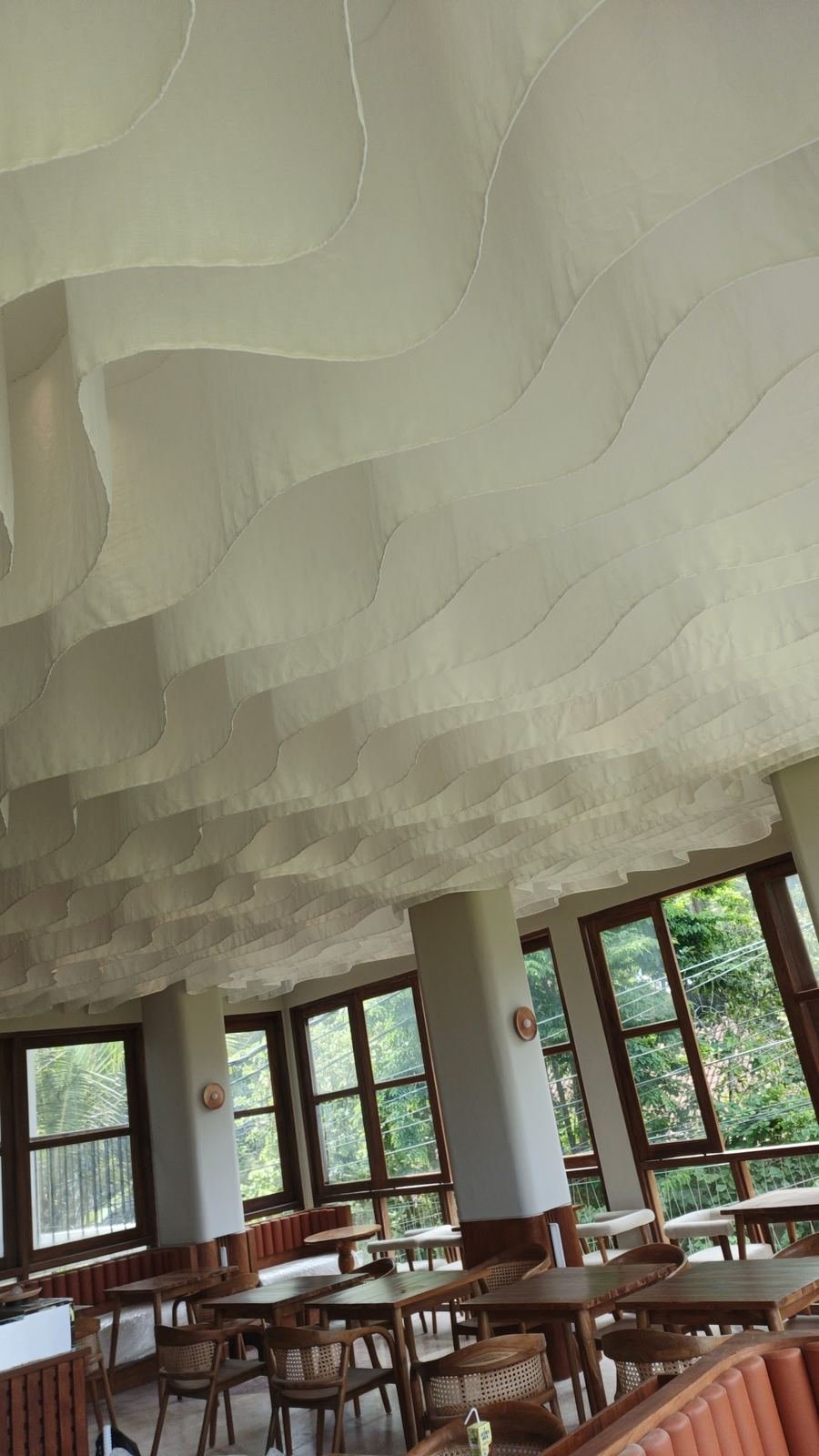 Restaurant with a draped, wave-shaped fabric ceiling