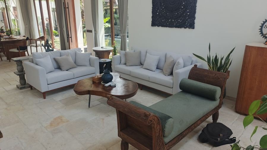 Living room with two grey sofas, a carved daybed and a timber coffee table